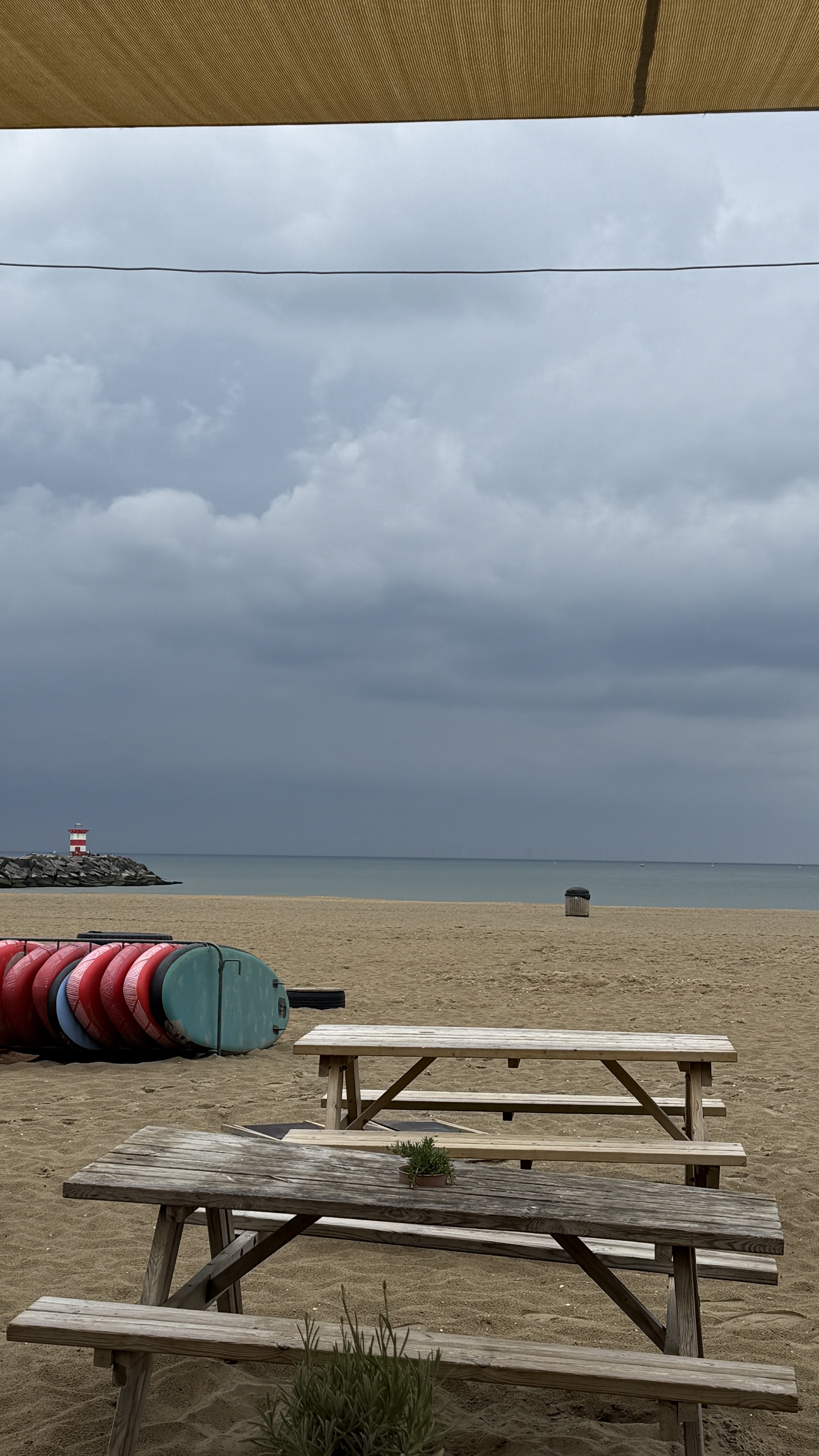 Het strand van Scheveningen met surfplanken op de voorgrond.