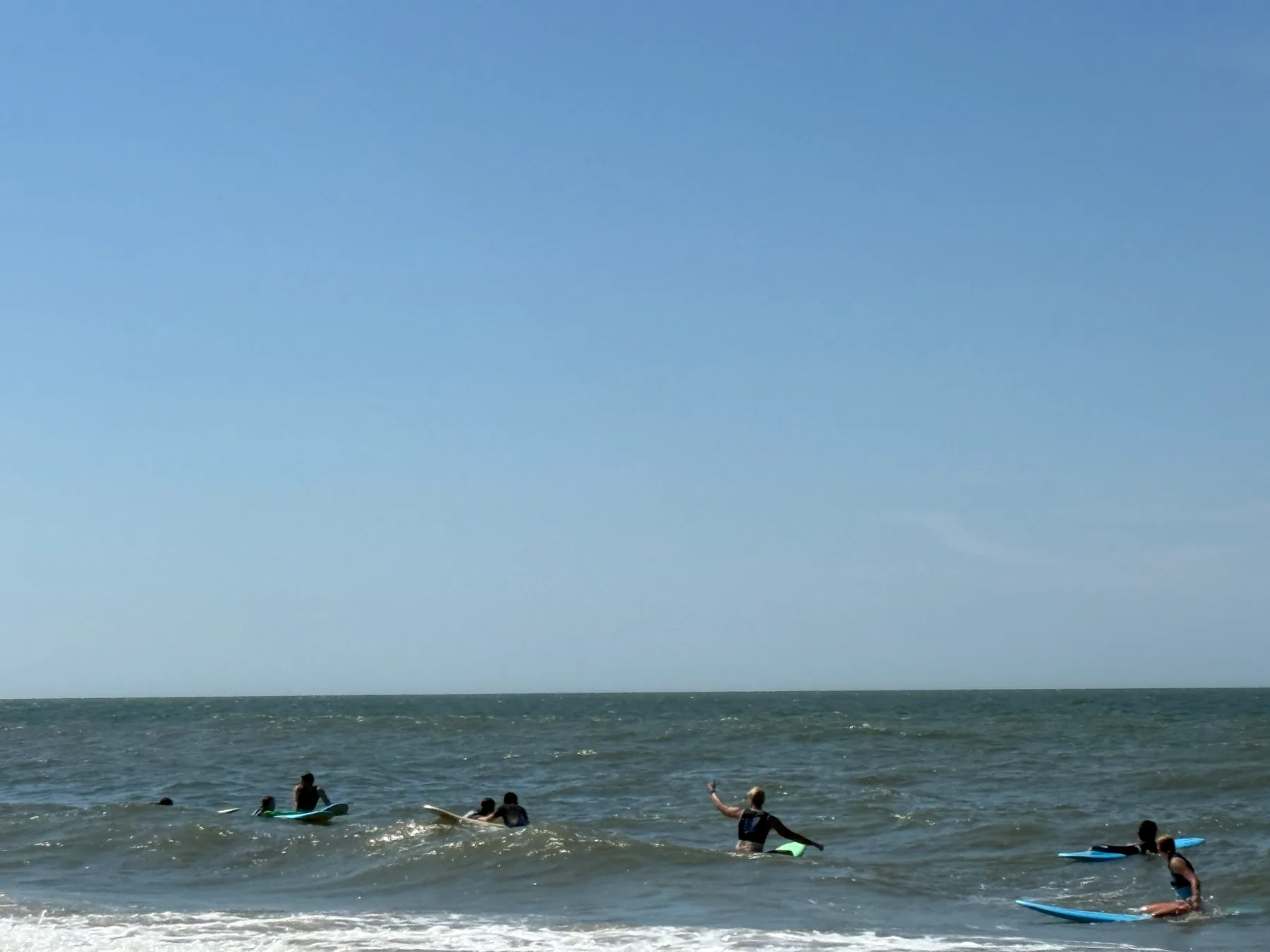 Een deelnemer peddelt tijdens een surfles in zee.